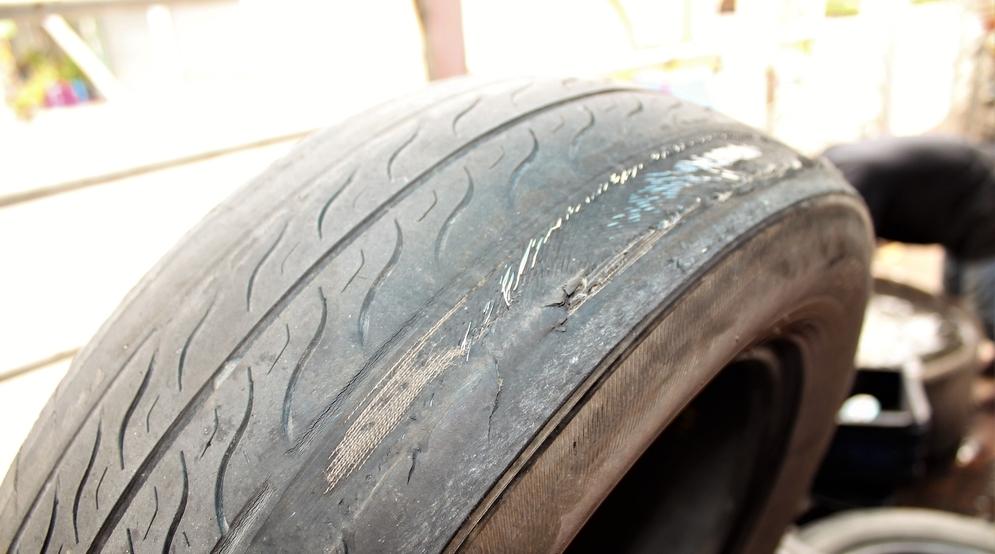 A car tire that is worn down on one edge