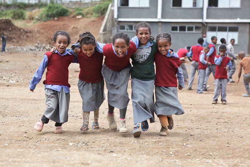 Five happy schoolgirls in uniform in front of a school in Addis Ababa, Ethiopia.